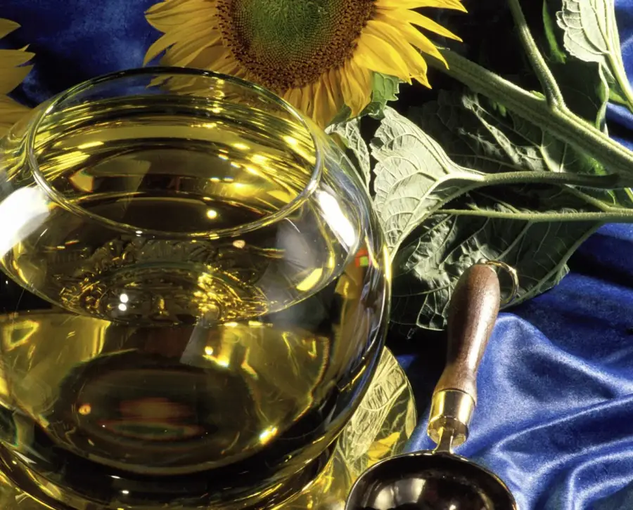 Sunflower oil in a glass bowl with sunflowers